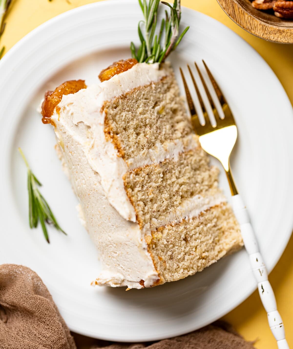 Slice of Vegan Banana Cake with Maple Buttercream lying on a small plate with a fork