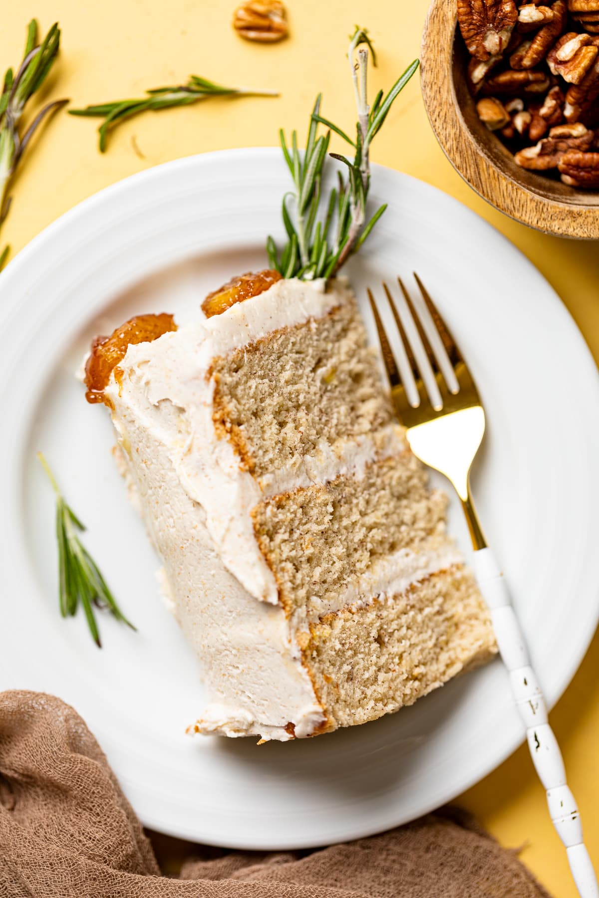 Slice of Vegan Banana Cake with Maple Buttercream lying on a small plate with a fork