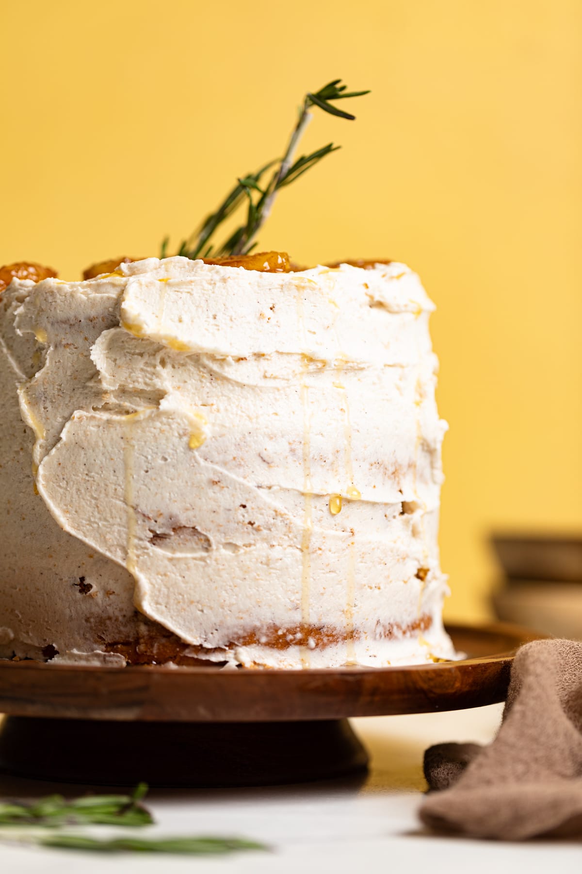 Vegan Banana Cake with Maple Buttercream on an elevated wooden serving dish