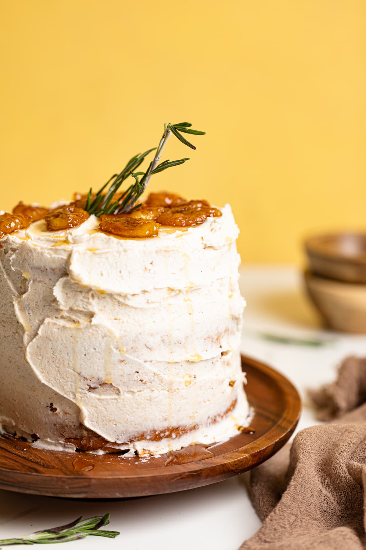 Vegan Banana Cake with Maple Buttercream on an elevated wooden serving dish