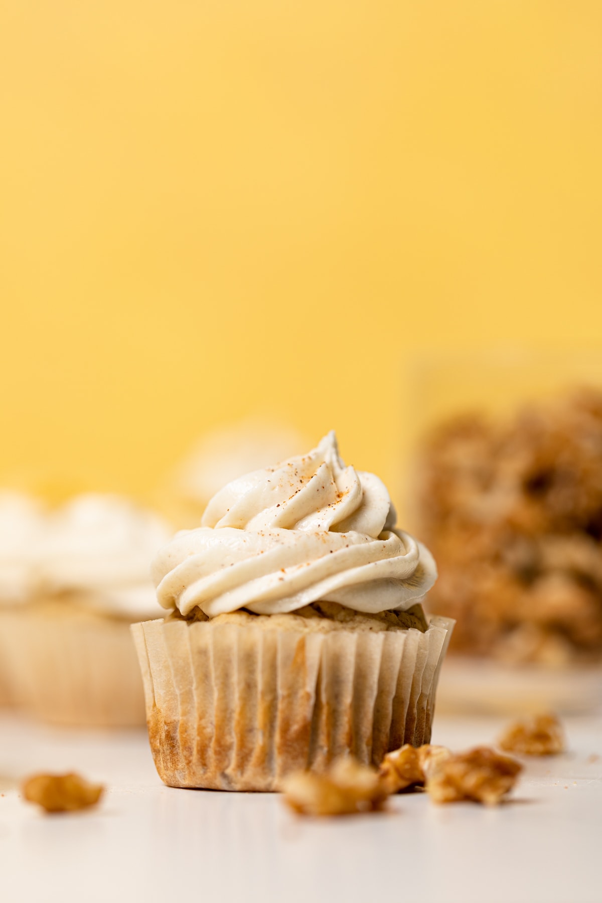 Banana Cupcake with Maple Buttercream on a white surface.