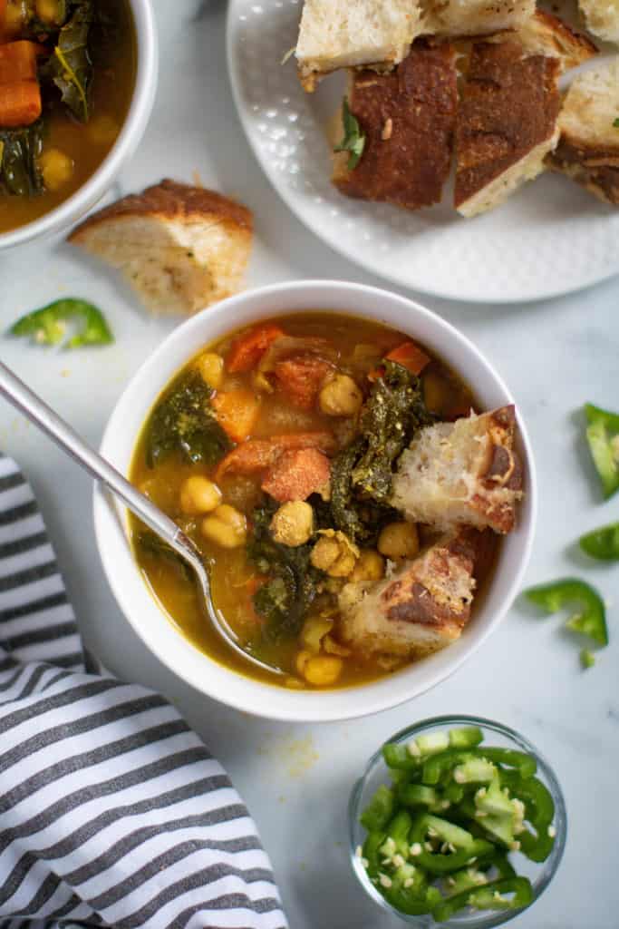 Spoon in a bowl of Vegan Tuscan Kale Chickpea Soup.