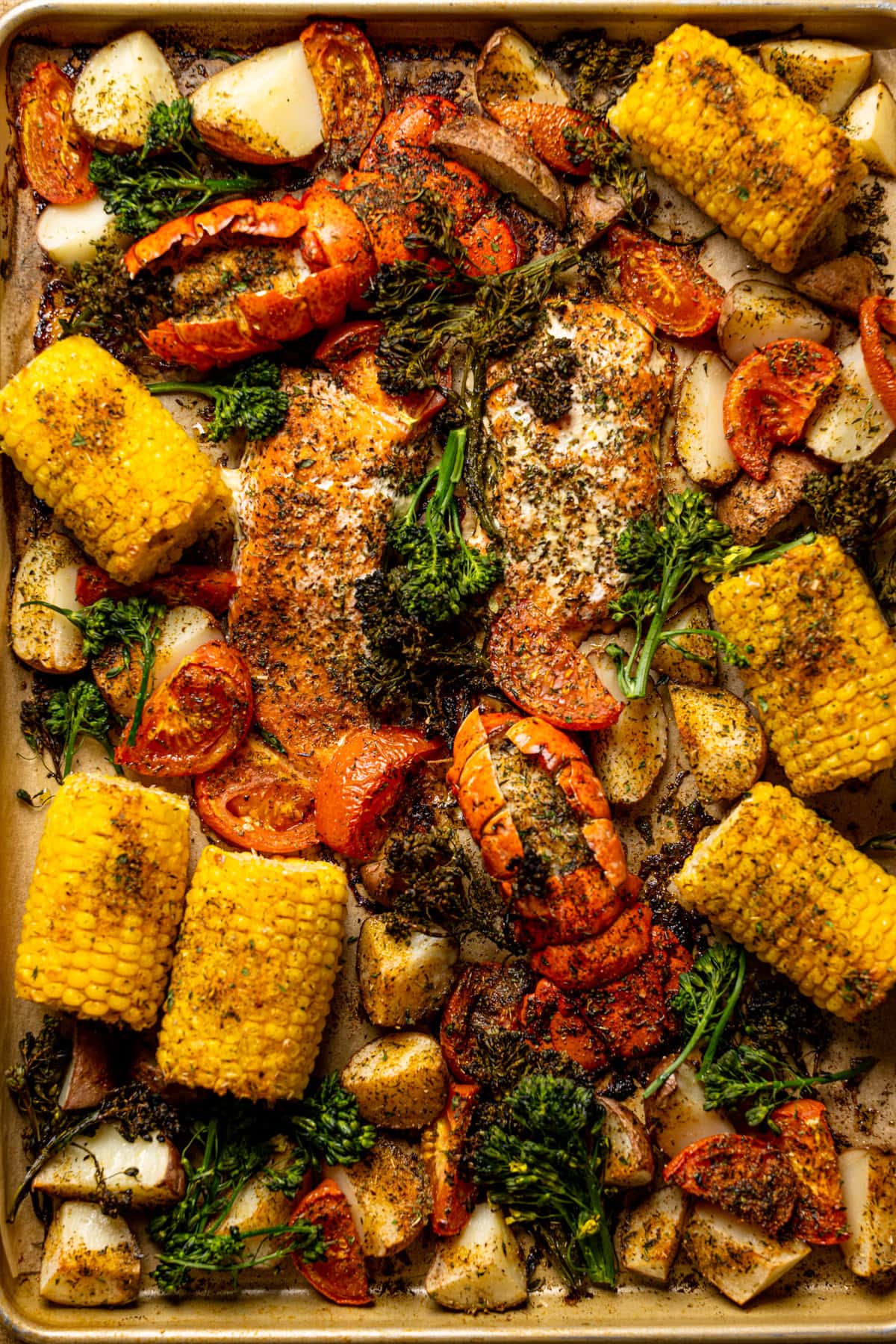 Sheet pan with seasoned salmon, lobster, and vegetables 