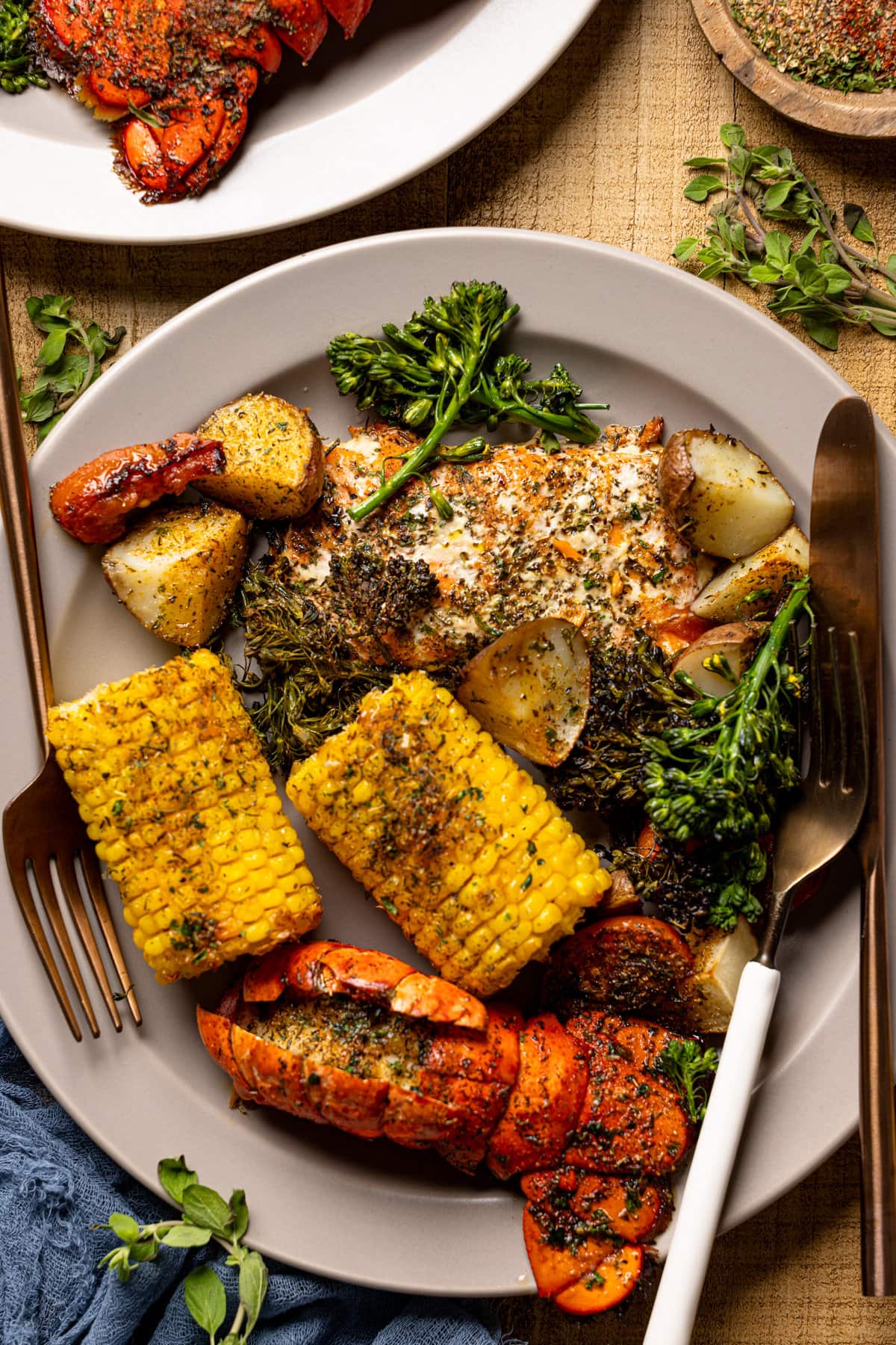 Plate and silverware with Garlic Herb Salmon, Lobster, and Veggies