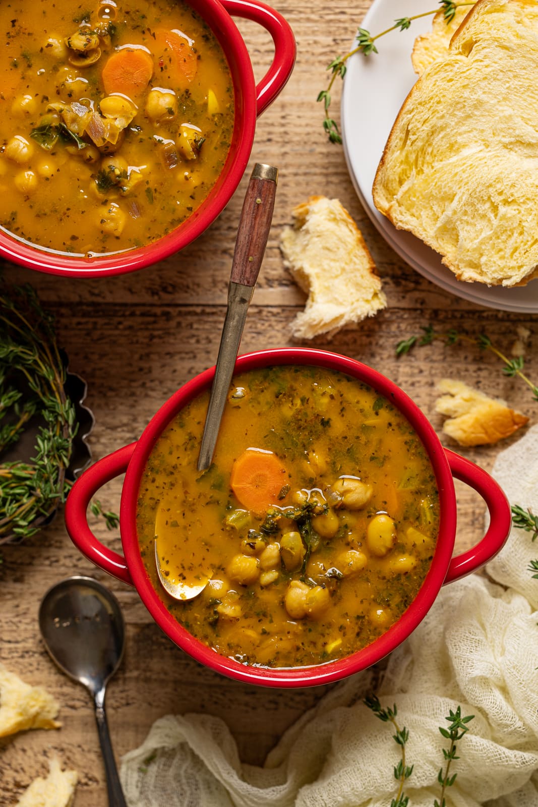 Up close shot of two bowls of soup with a spoon in the bowl.