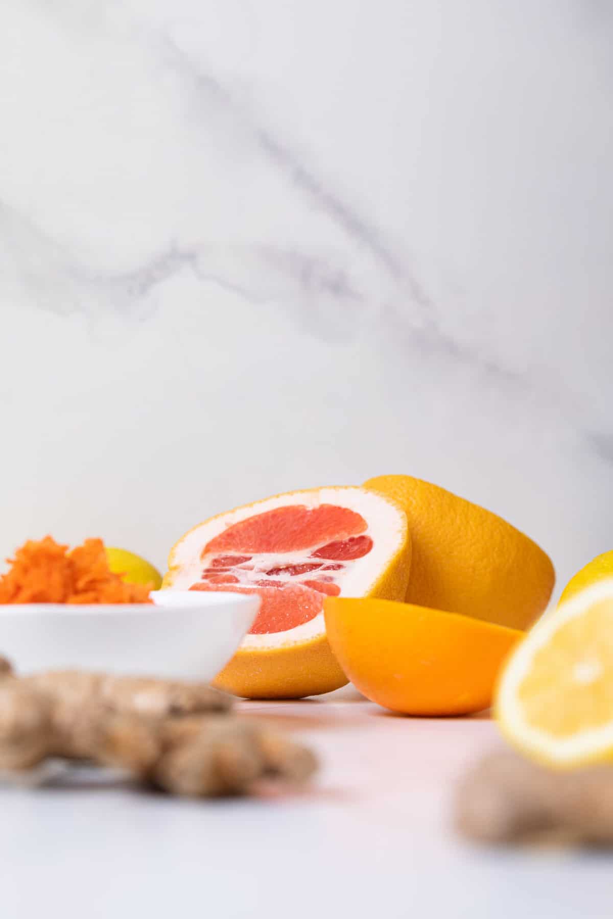 Fresh orange slices and ginger root on a marble background.