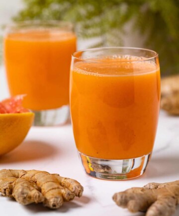 Small glasses of Carrot Ginger Citrus Turmeric Juice.