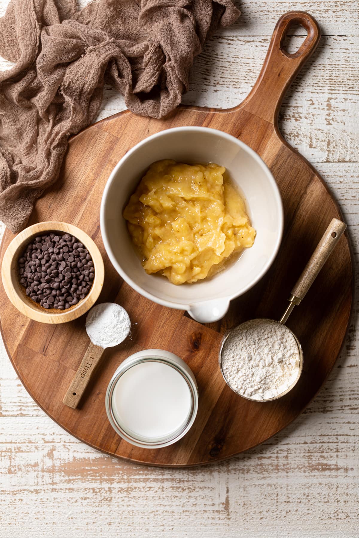 Ingredients for Vegan Banana Chocolate Chip Pancakes including mashed bananas, almond milk, and flour