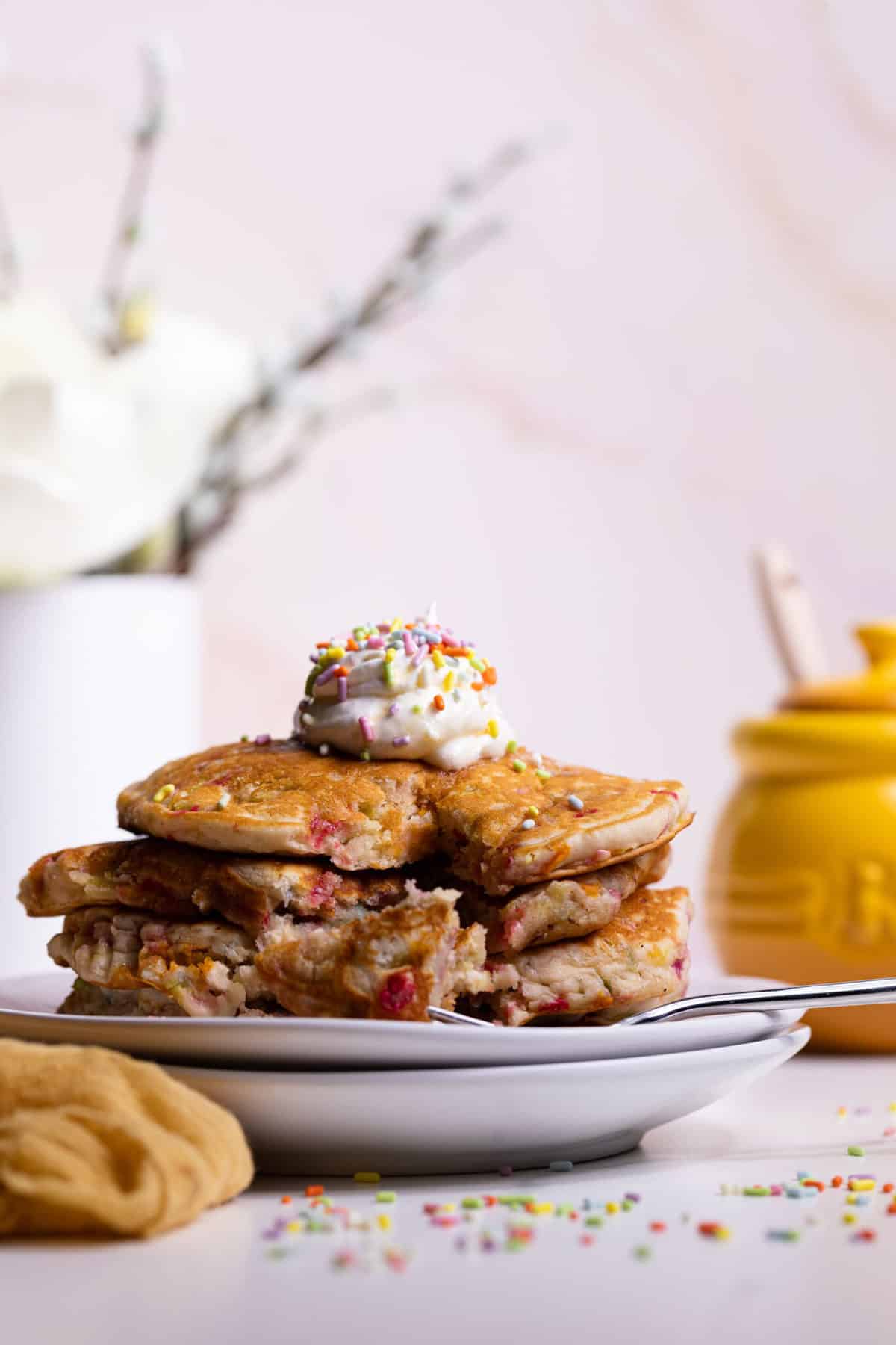 Stack of Funfetti Vegan Pancakes with a slice missing