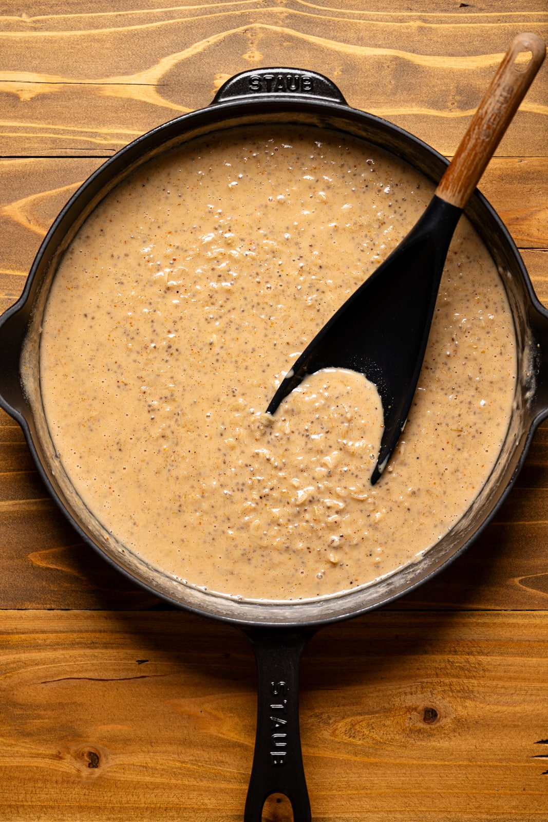 Oatmeal in a black skillet with a spoon.