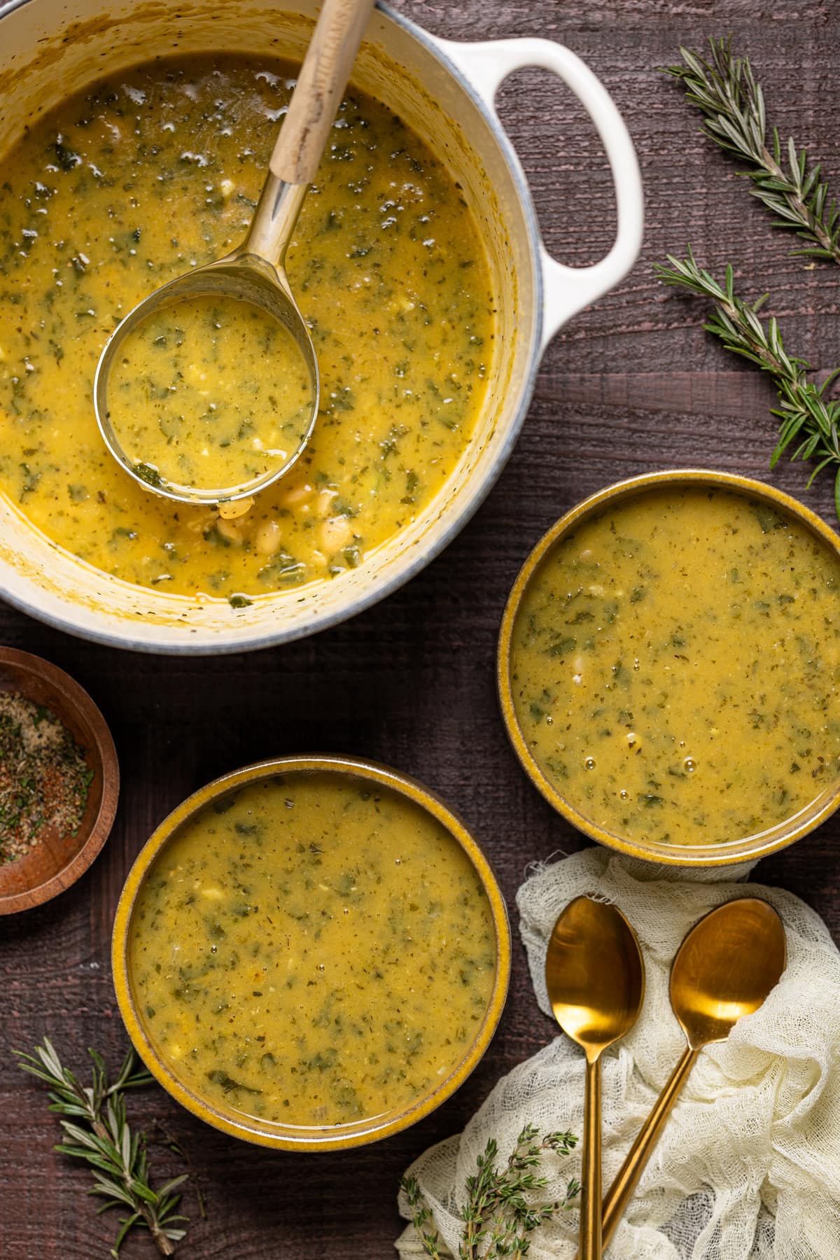 Two bowls and one Dutch oven of Creamy Vegan White Bean Soup 