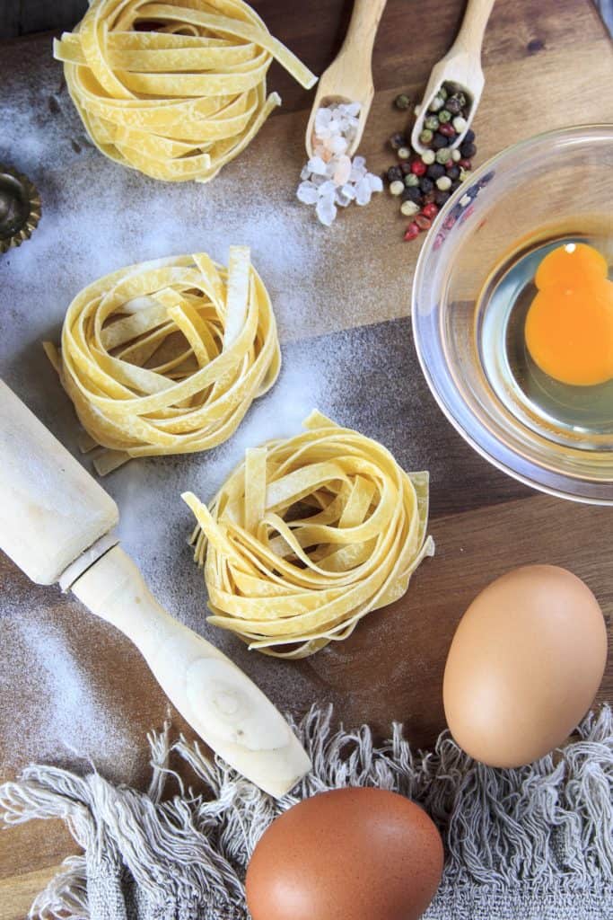 Noodles and eggs on a wooden countertop.