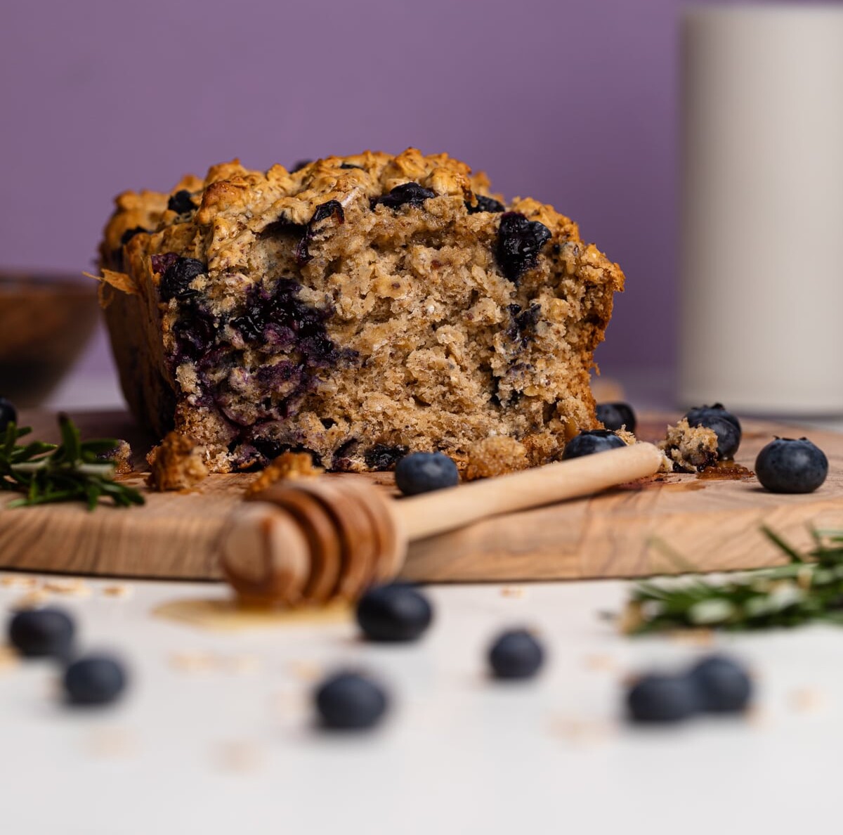 Blueberry Oatmeal Breakfast Bread cut in half on a cutting board.