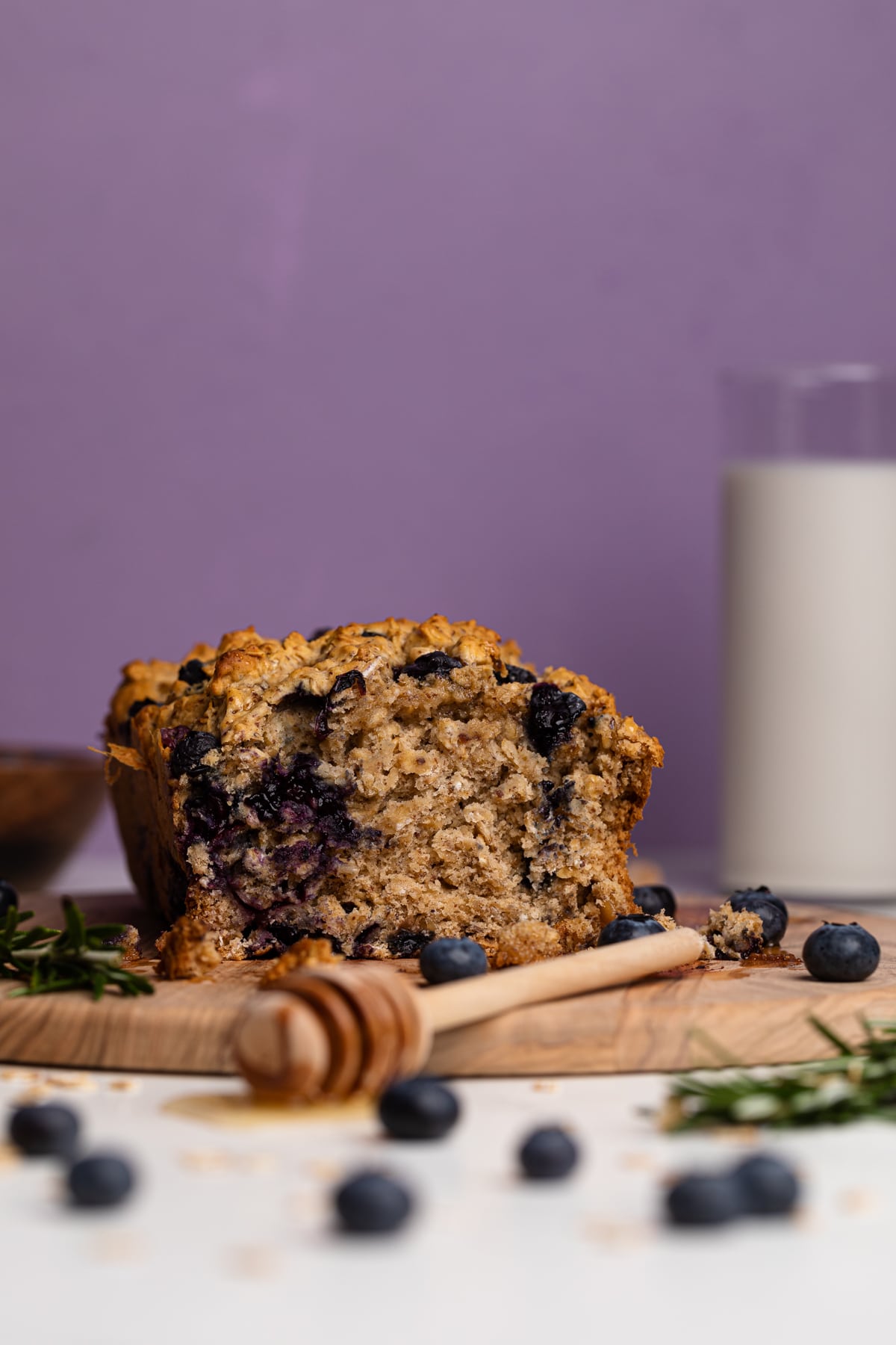 Blueberry Oatmeal Breakfast Bread cut in half on a cutting board.