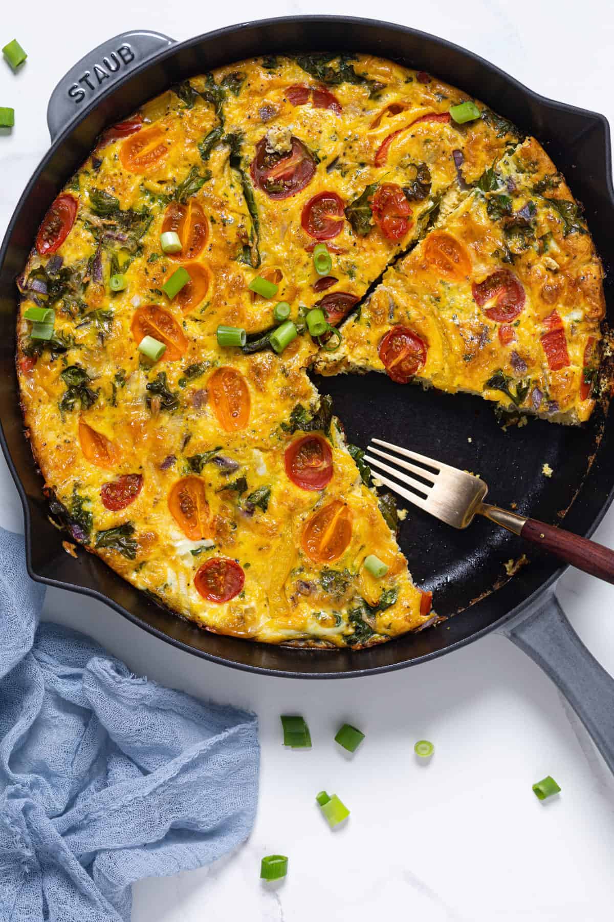 Veggie Frittata missing a slice in a skillet.