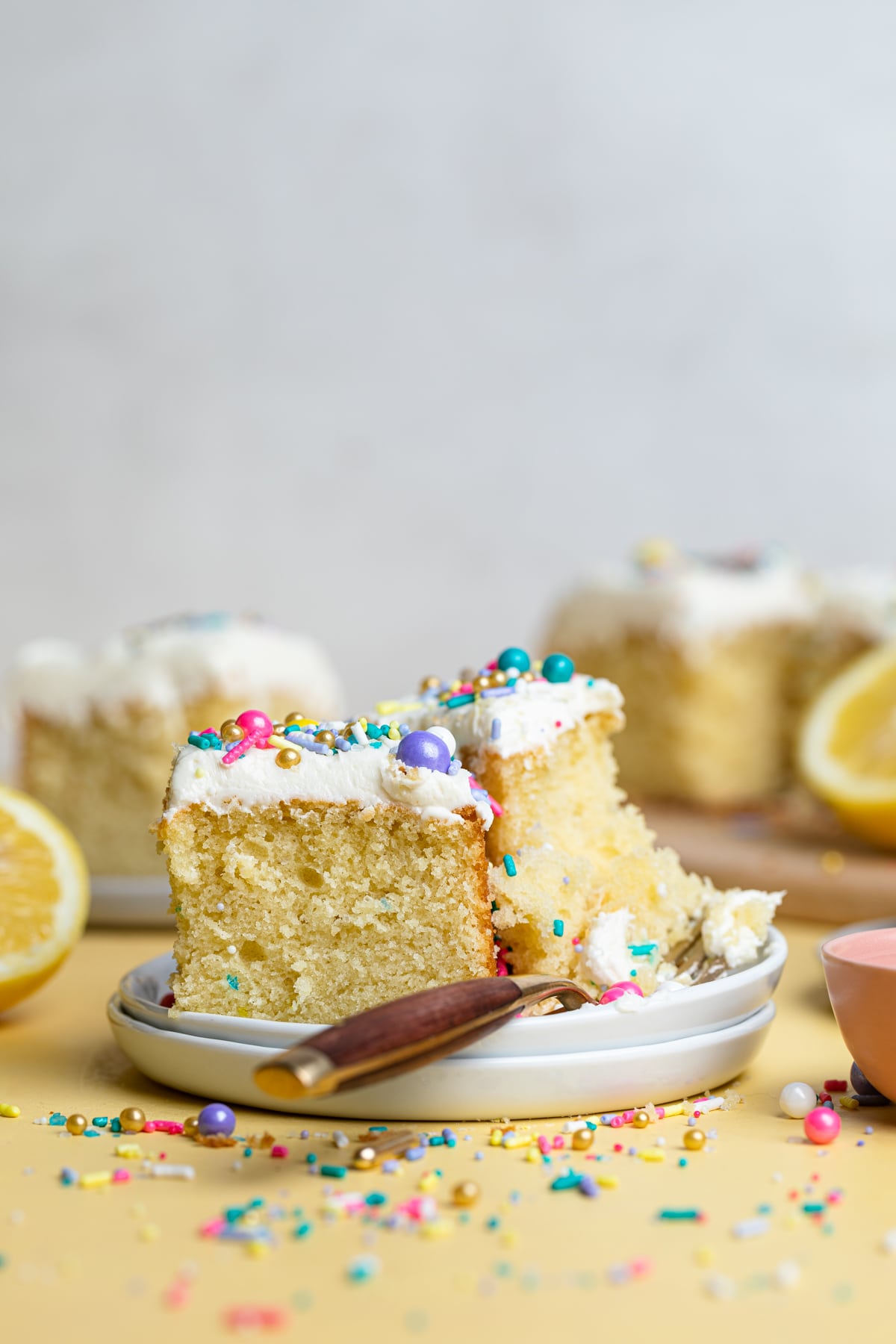 Fork and two pieces of Lemon Birthday Sheet Cake on plates.