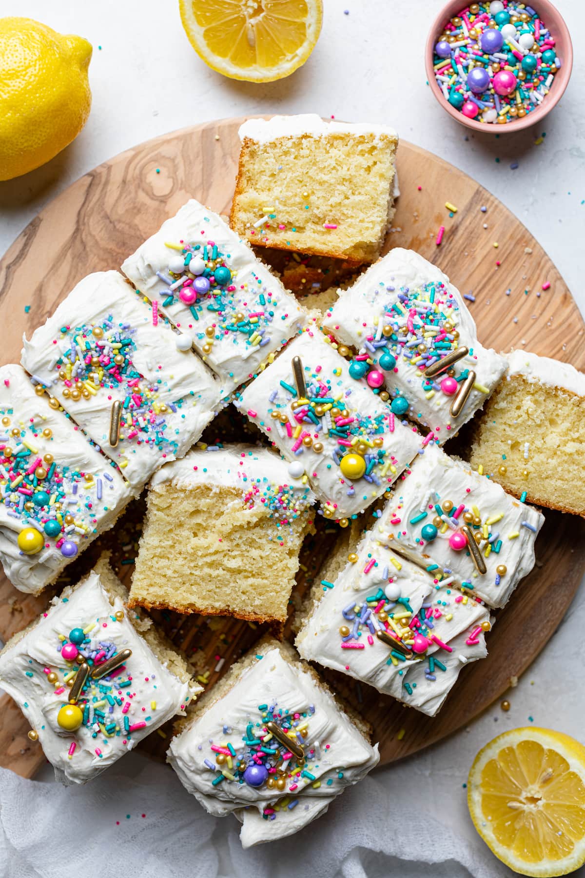 Pieces of Lemon Birthday Sheet Cake on a wooden board.