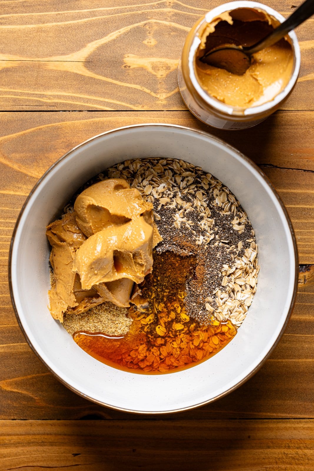 All ingredients together in a large white bowl on a brown wood table.