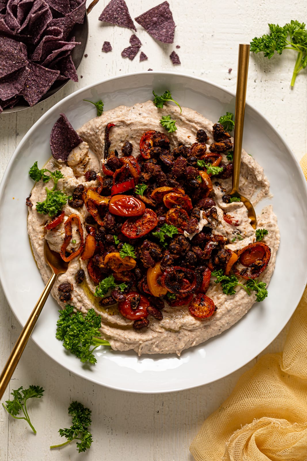 Plate of Garlic Herb Three Bean Dip with two spoons