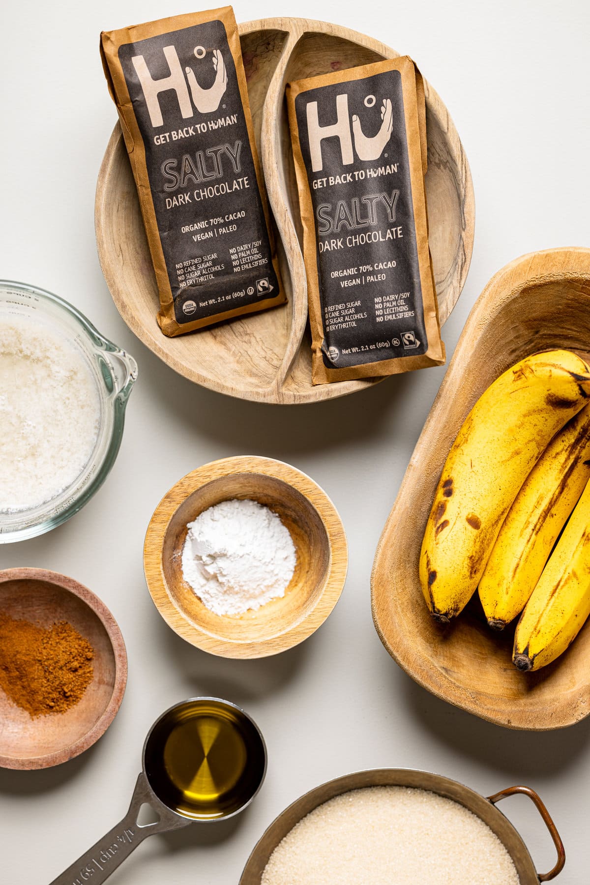 Ingredients for Vegan Chocolate Chip Banana Cake including bananas, chocolate, and sugar.