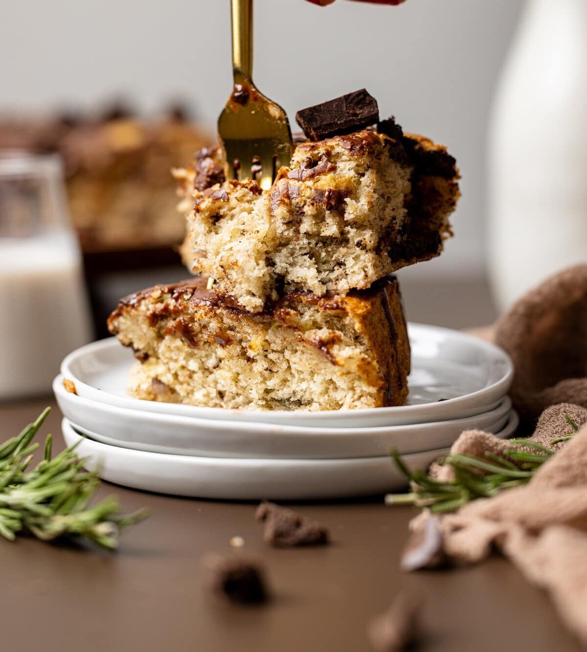 Fork stabbing into two stacked slices of Vegan Chocolate Chip Banana Cake.