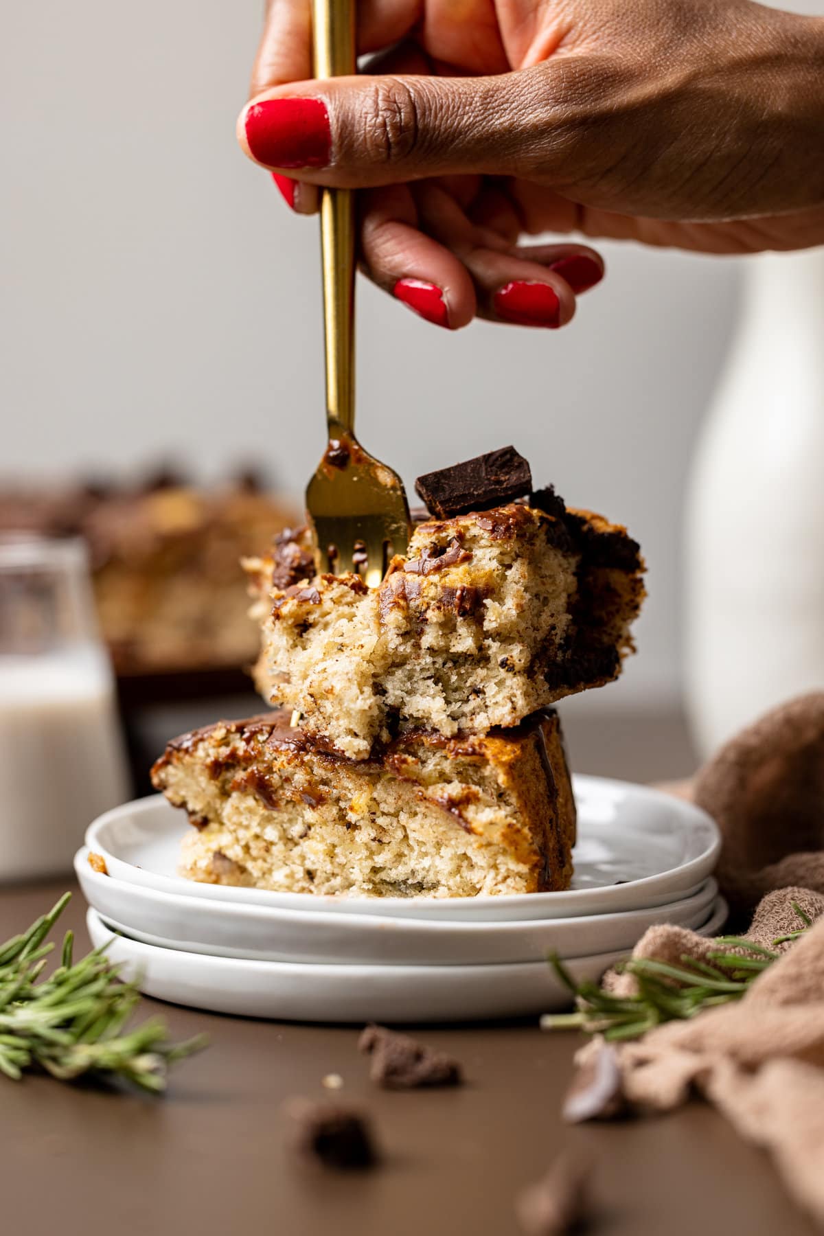 Fork stabbing into two stacked slices of Vegan Chocolate Chip Banana Cake.