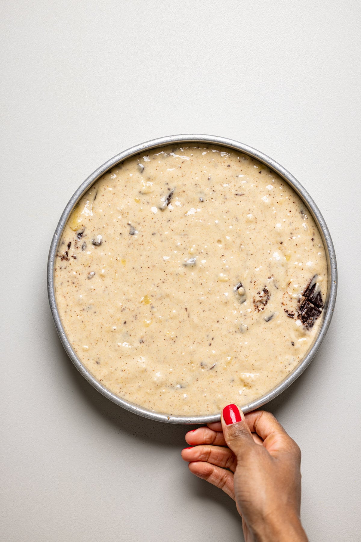 Vegan Chocolate Chip Banana Cake batter in a round pan.