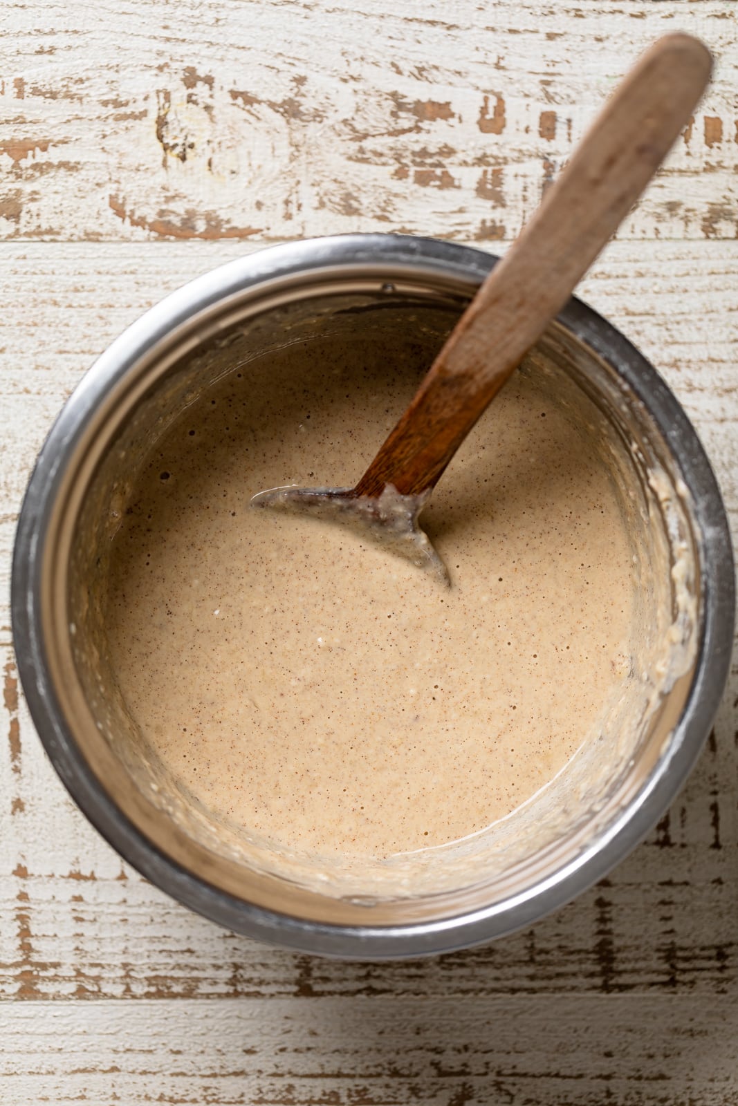 Wooden spoon in a bowl of Healthy Banana Bread Pancake batter