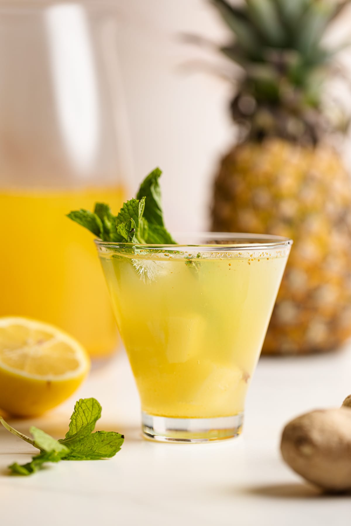 Pineapple Ginger Turmeric Lemonade in front of a pineapple.