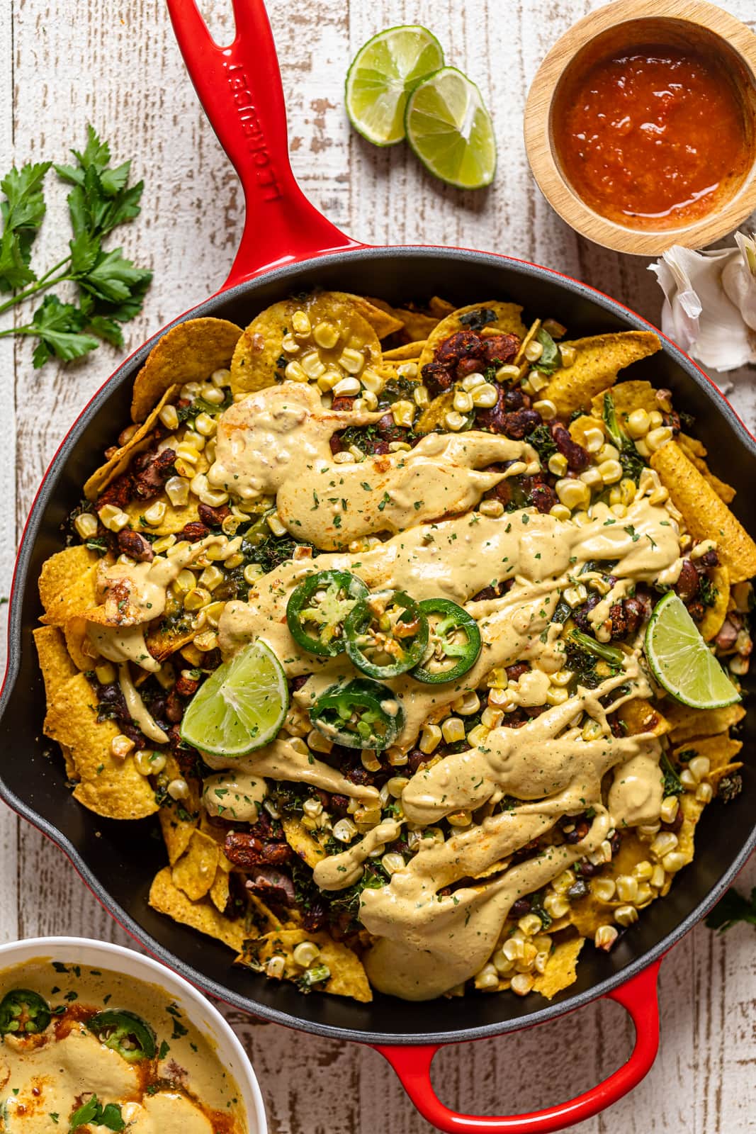 Overhead shot of Loaded Vegan Queso Skillet Nachos in a red Le Creuset pan