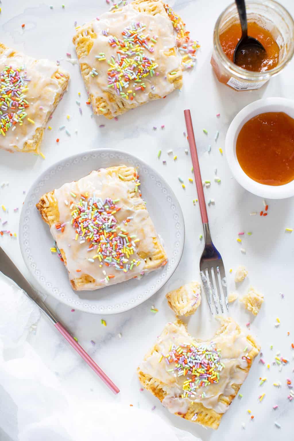 Vegan Apricot Pop Tarts topped with sprinkles on a plate.