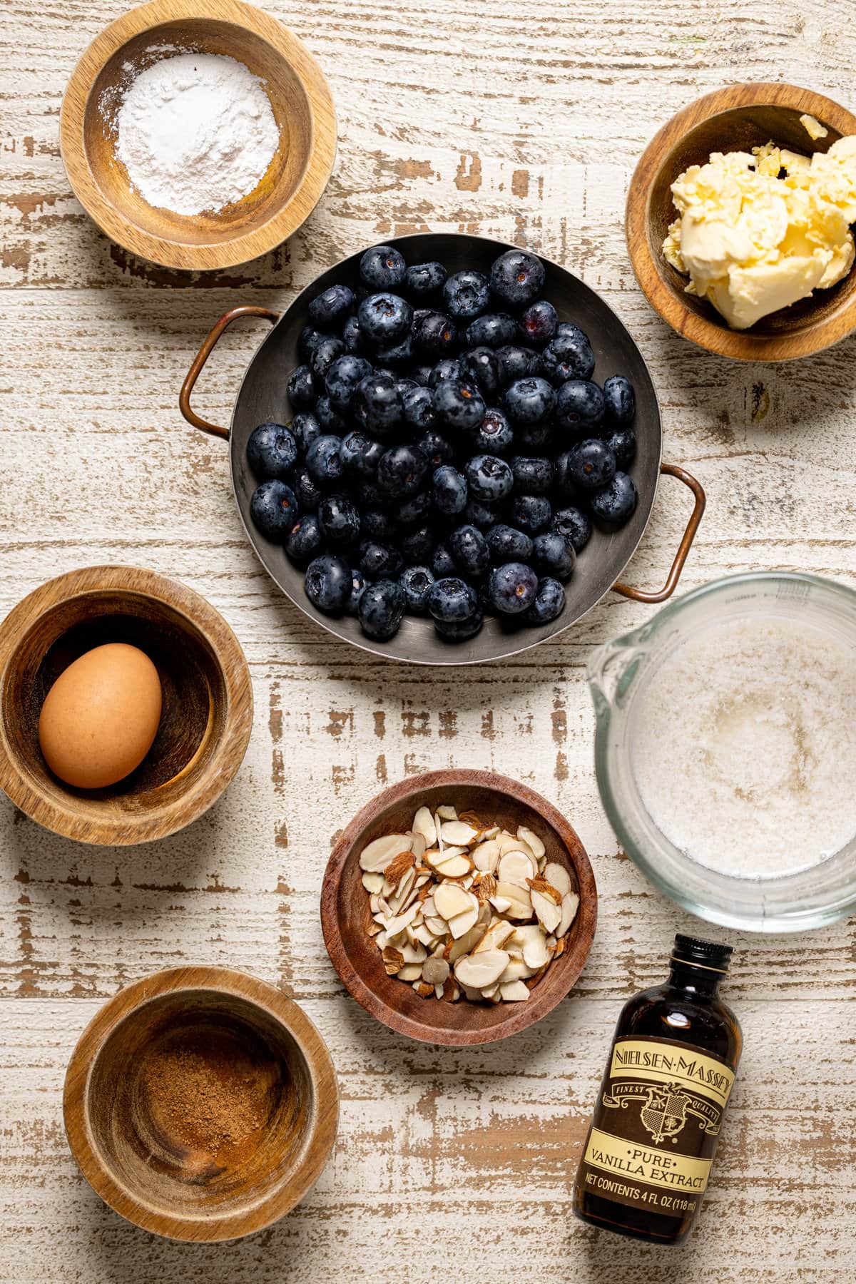 Ingredients including an egg, vanilla extract, and blueberries.