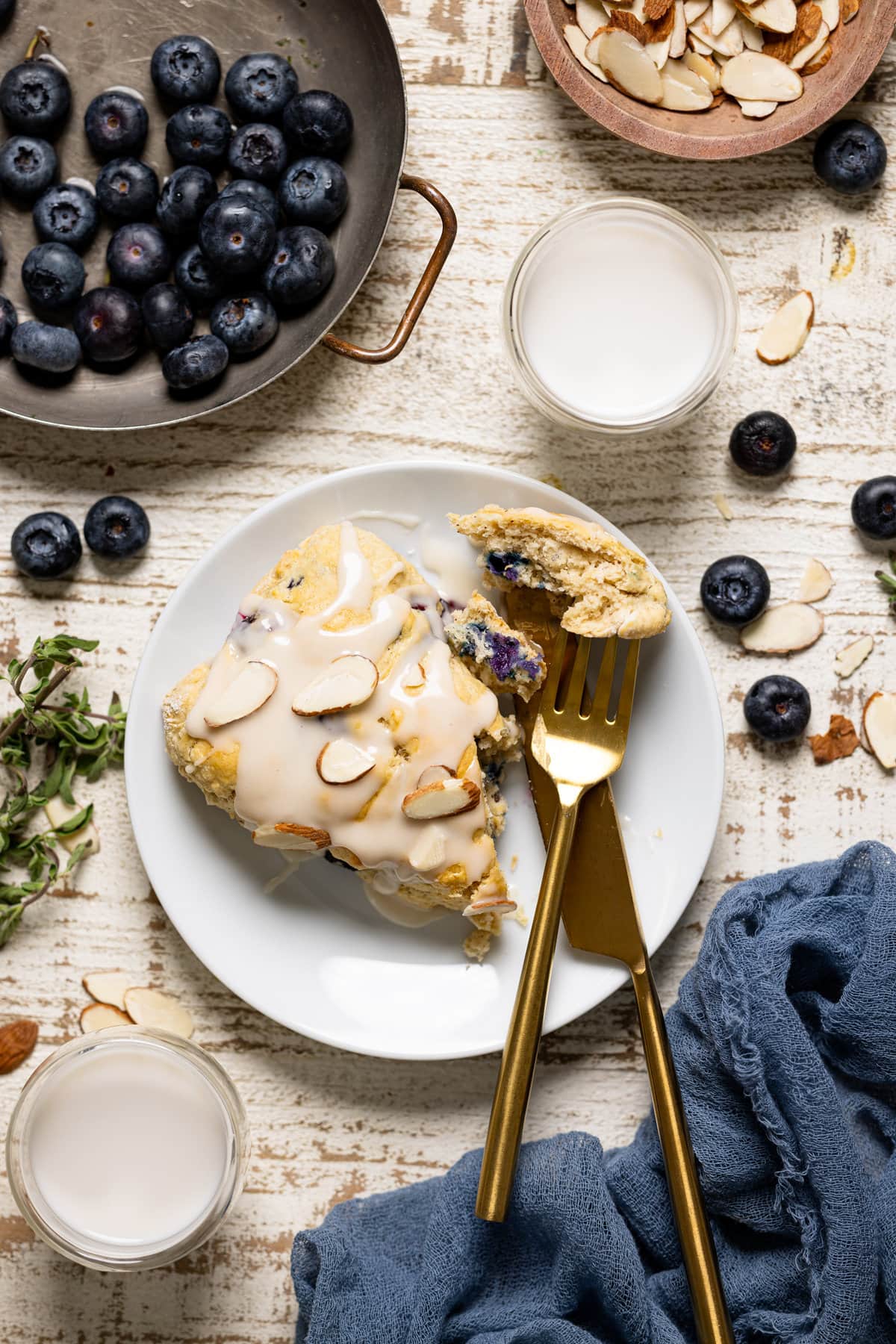Dairy-Free Blueberry Almond Scone on a plate with gold silverware.