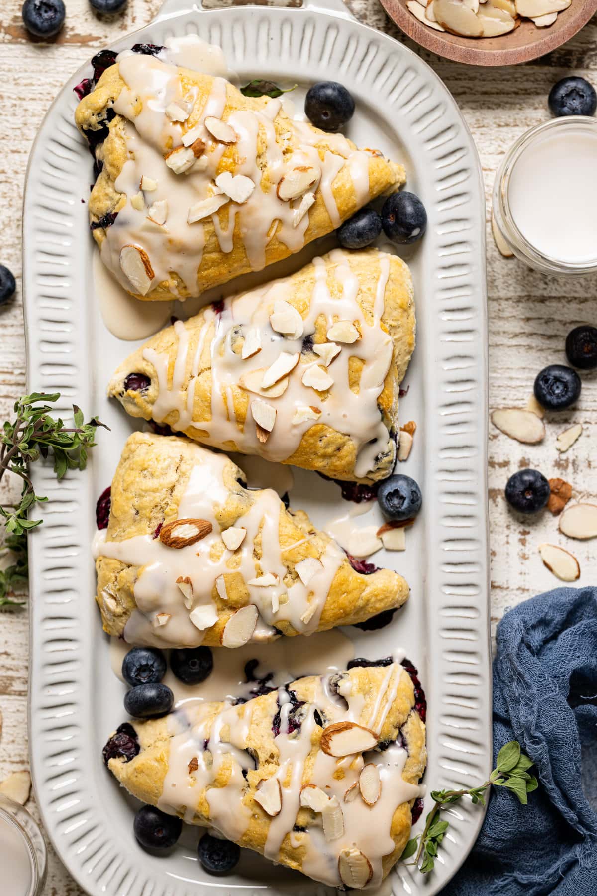 Dairy-Free Blueberry Almond Scones on a plate with blueberries and slivered almonds.