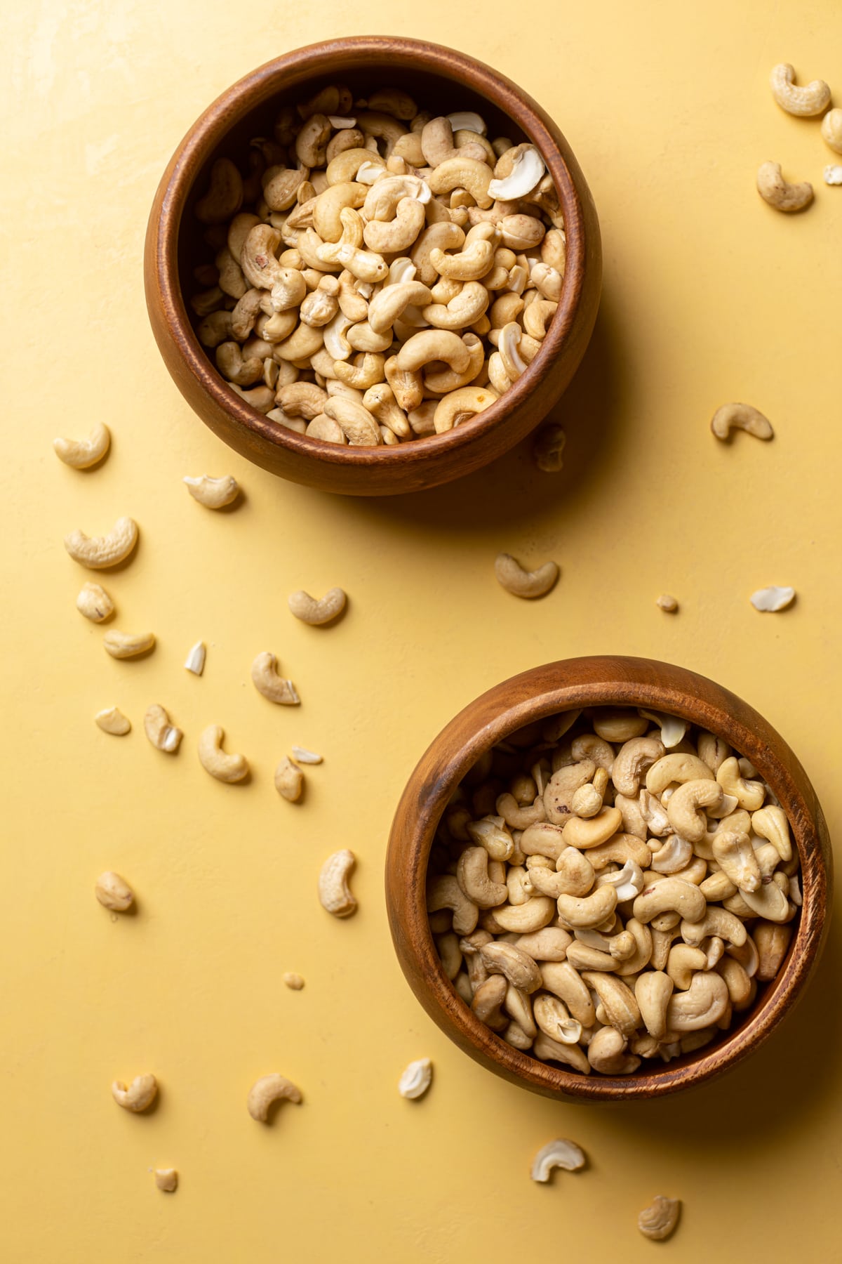 Two wooden bowls of cashews