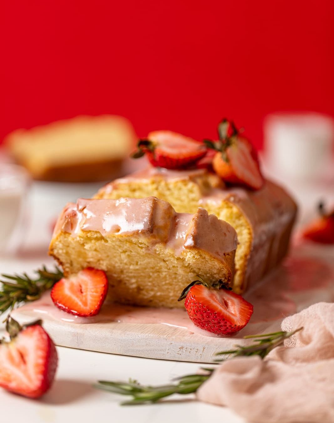 Slice falling from a Cream Cheese Pound Cake with Strawberry Glaze.