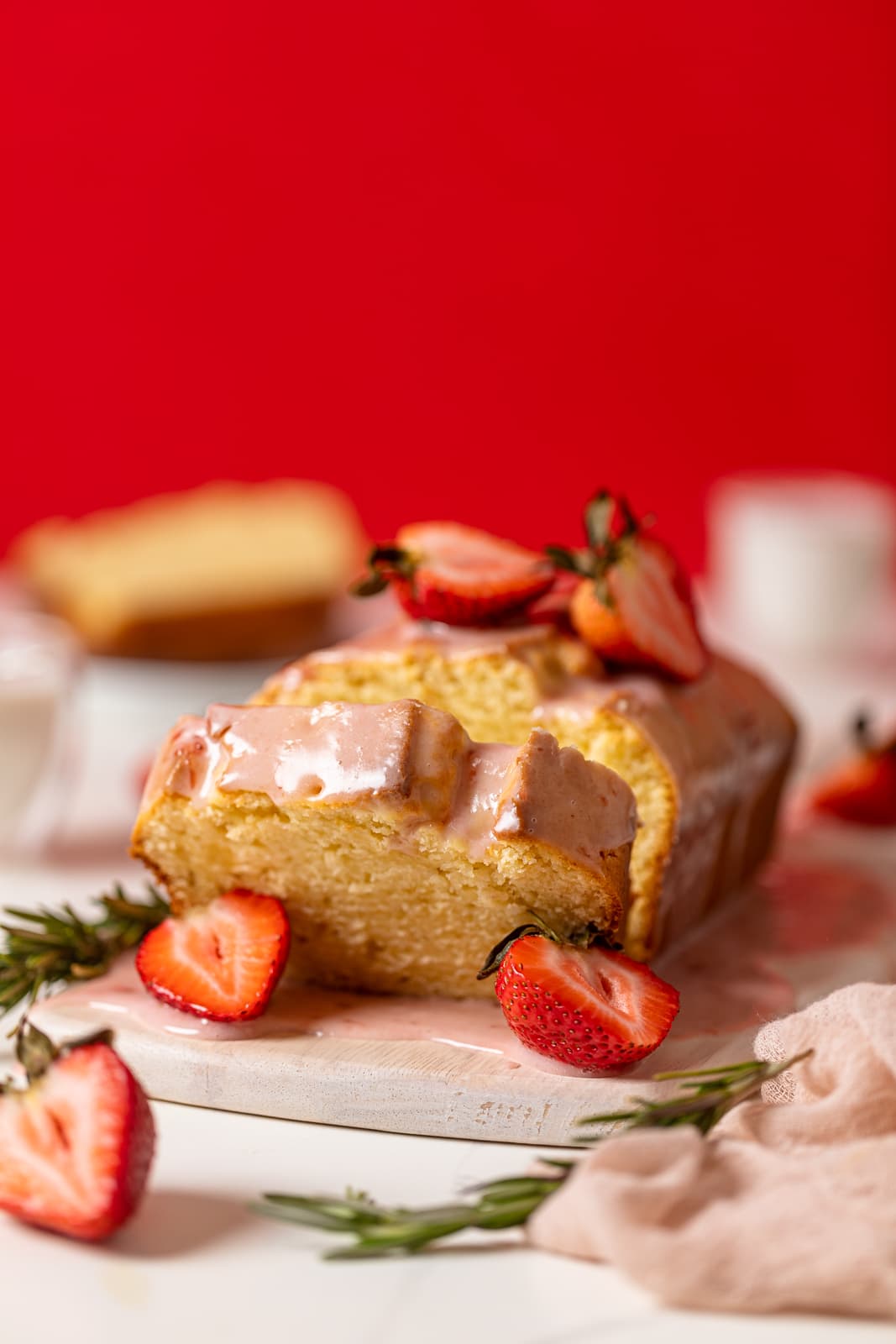 Slice leaning from a Cream Cheese Pound Cake with Strawberry Glaze.