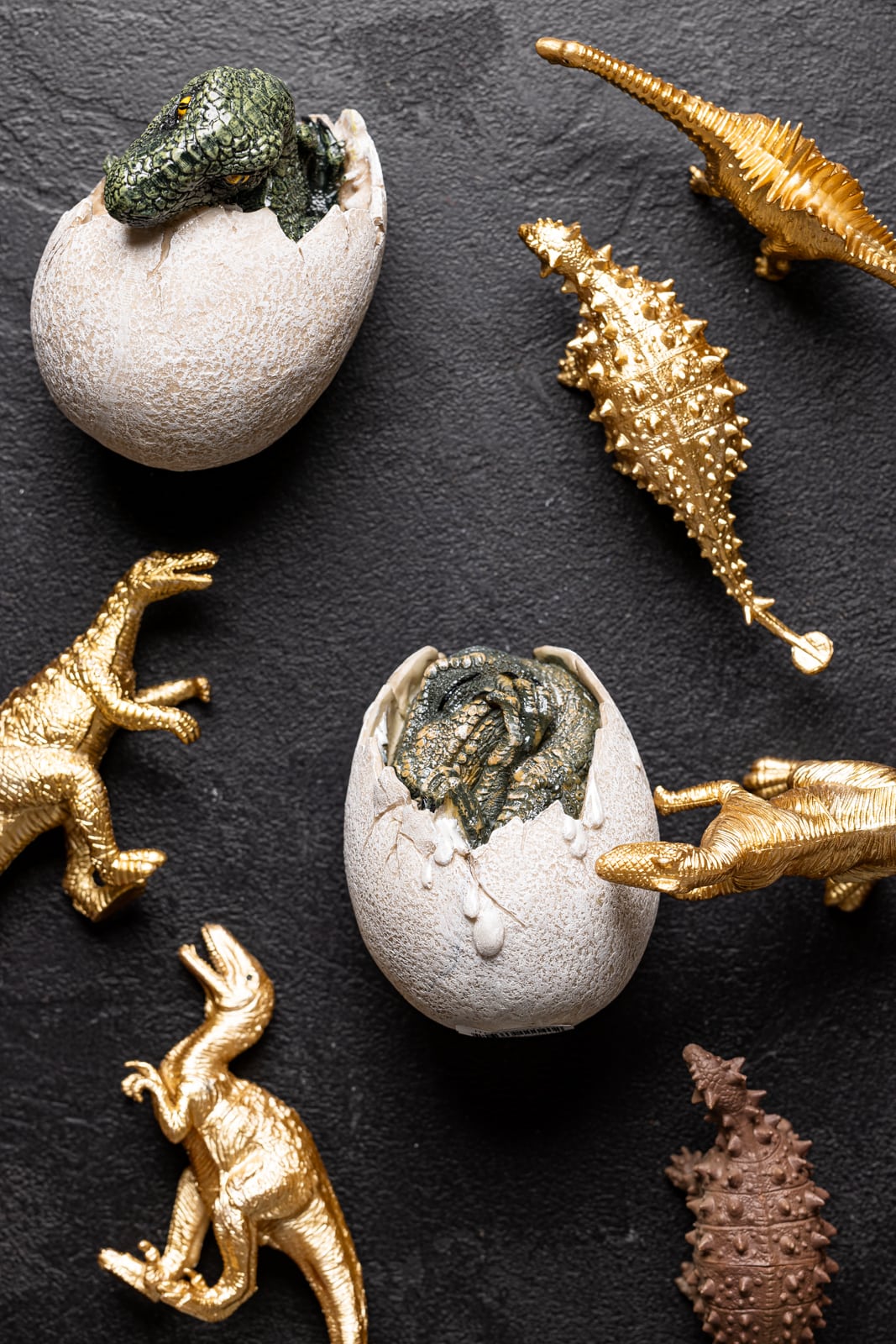 An array of dinosaur toys on a black table.