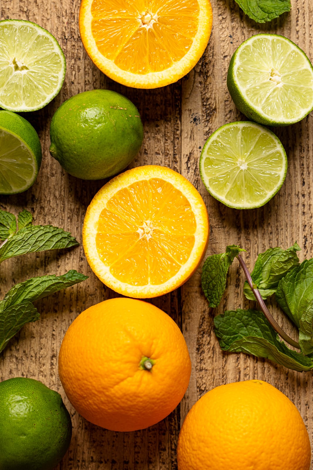 Up close shot of sliced oranges, lime, and fresh mint leaves.