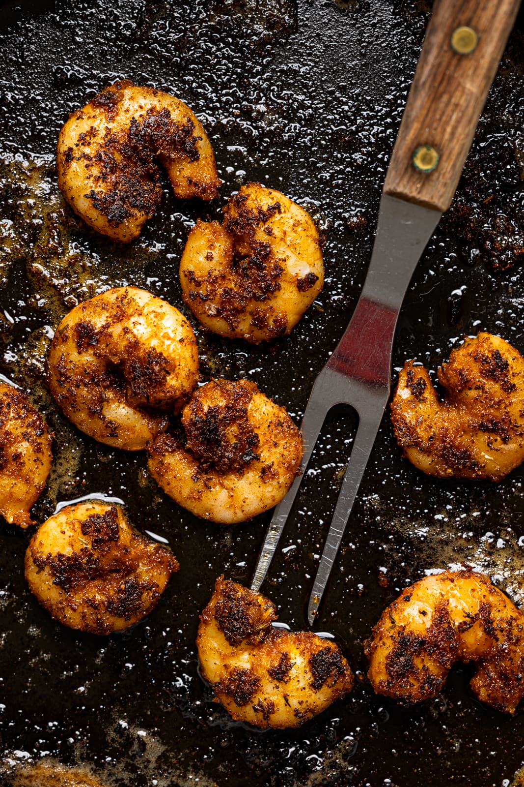 Up close shot of the blackened shrimp with a fork.