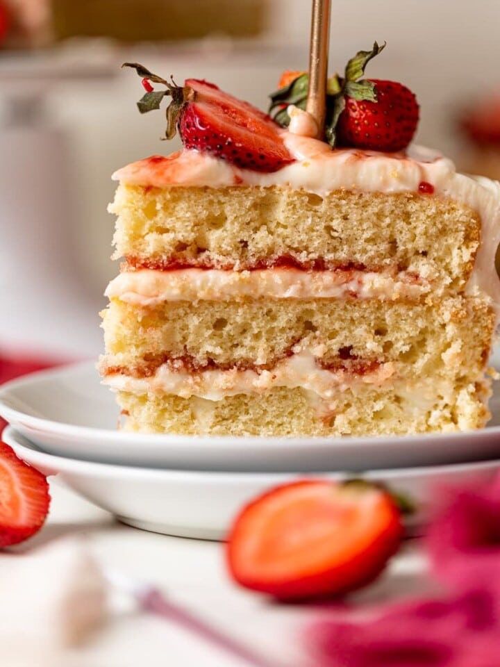 Slice of Strawberry Shortcake Birthday Cake on two small, stacked plates.