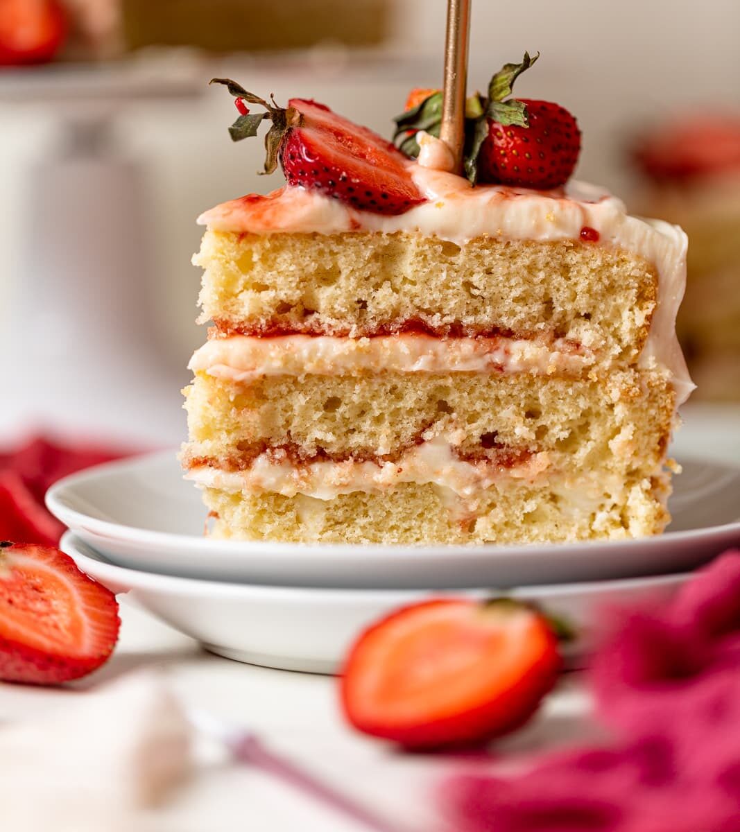 Slice of Strawberry Shortcake Birthday Cake on two small, stacked plates.