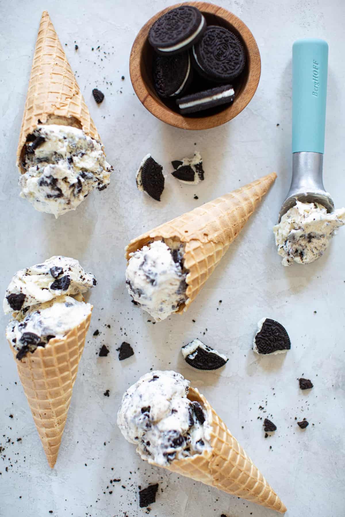 Ice cream cones and an ice cream scoop of No-Churn Cookies and Cream Ice Cream.