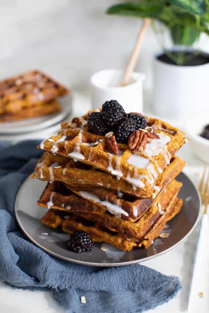 Flourless Vegan Sweet Potato Oats Waffles topped with blackberries and nuts.