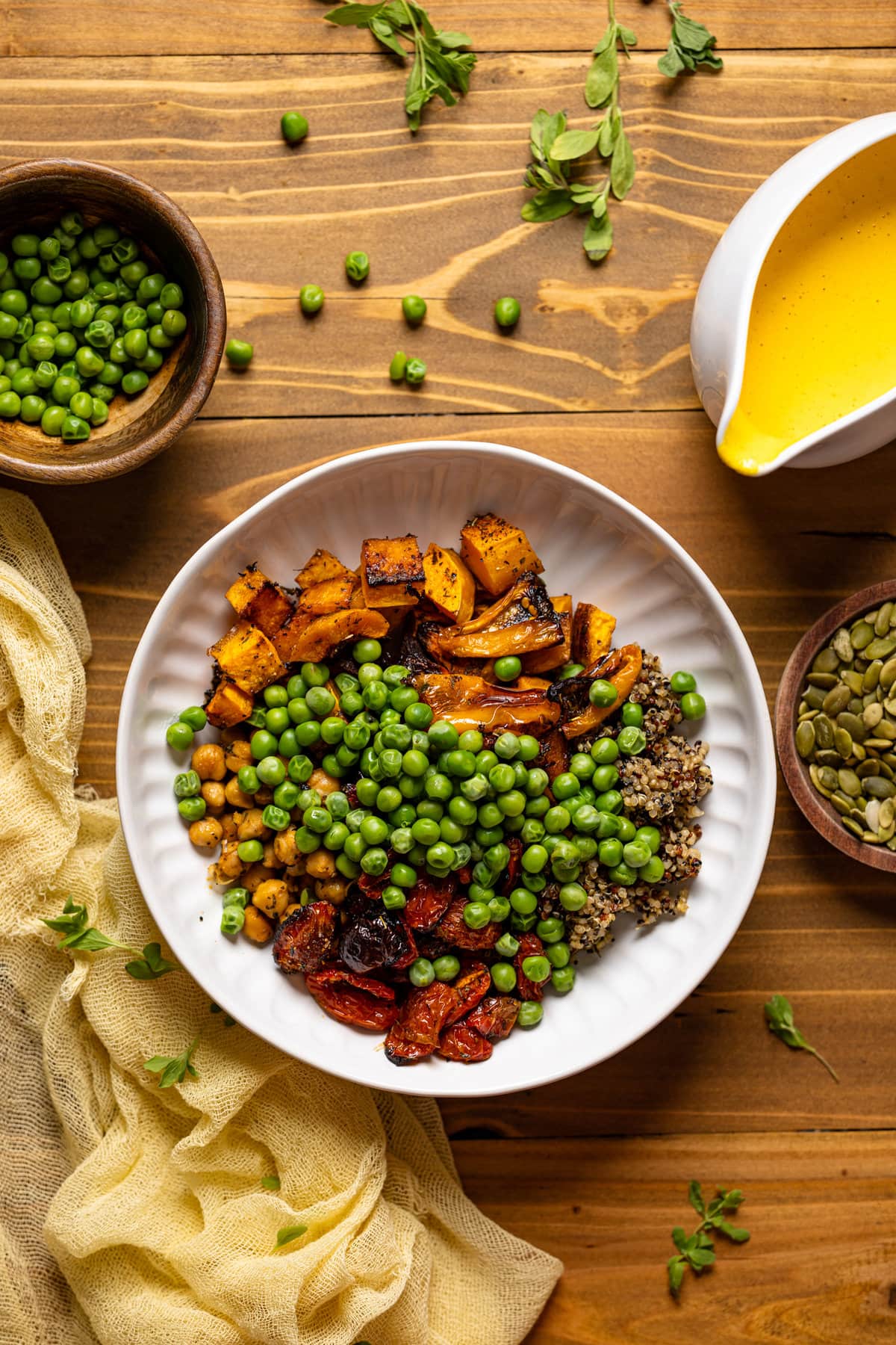 Overhead shot of a Savory Chickpea Quinoa Buddha Bowl next to a bowl of peas