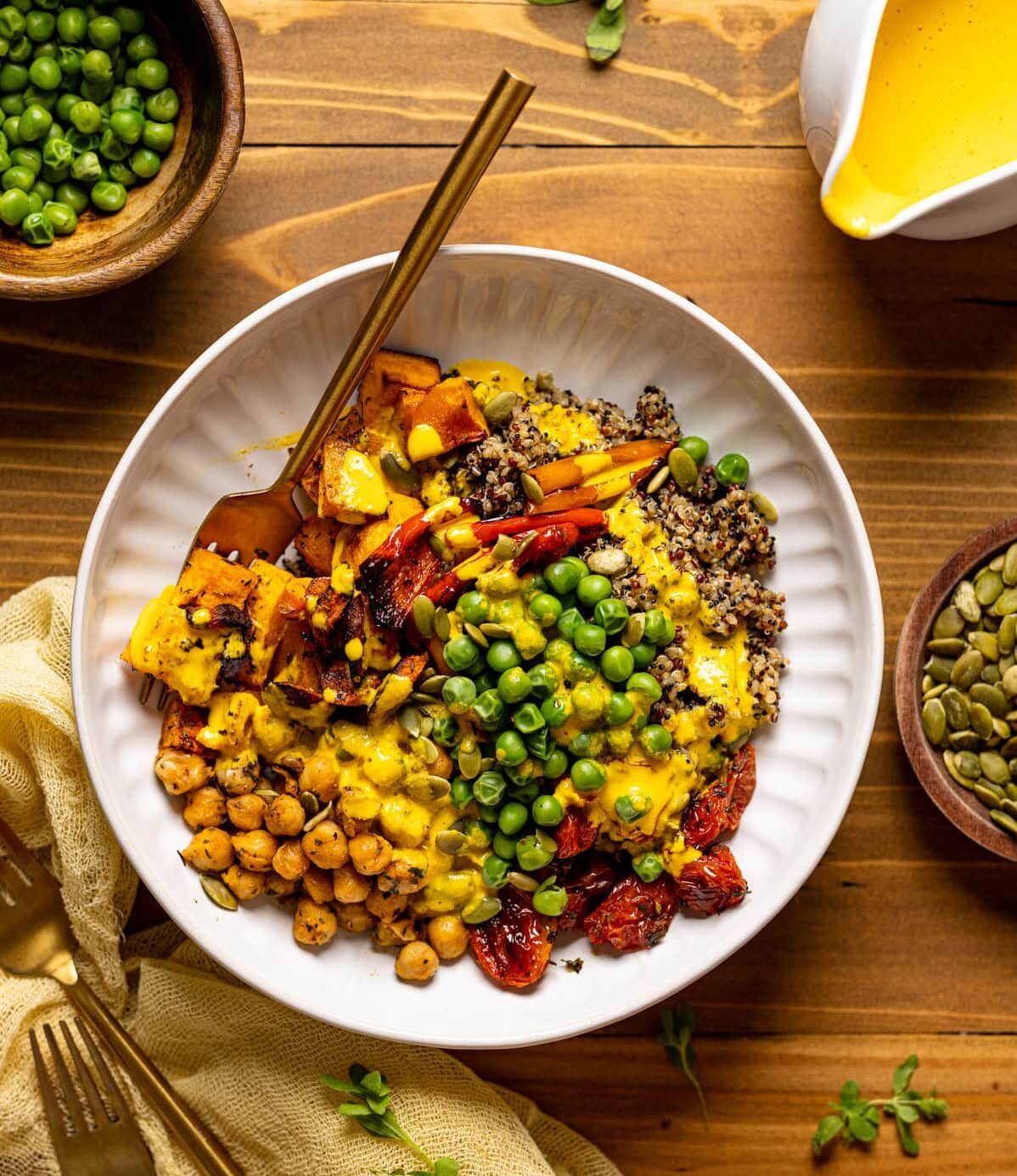 Overhead shot of a Savory Chickpea Quinoa Buddha Bowl next to a bowl of peas