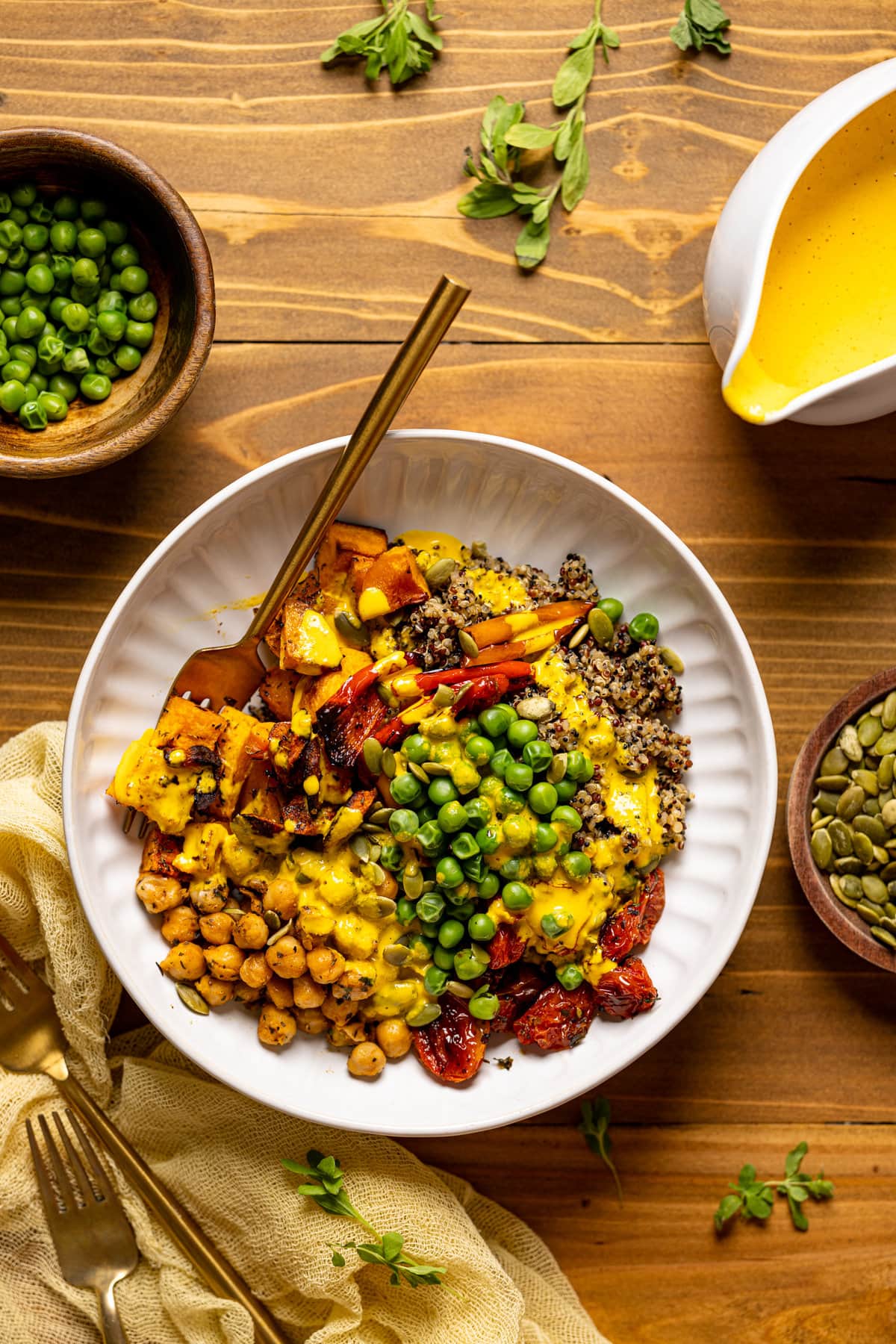 Overhead shot of a Savory Chickpea Quinoa Buddha Bowl next to a bowl of peas