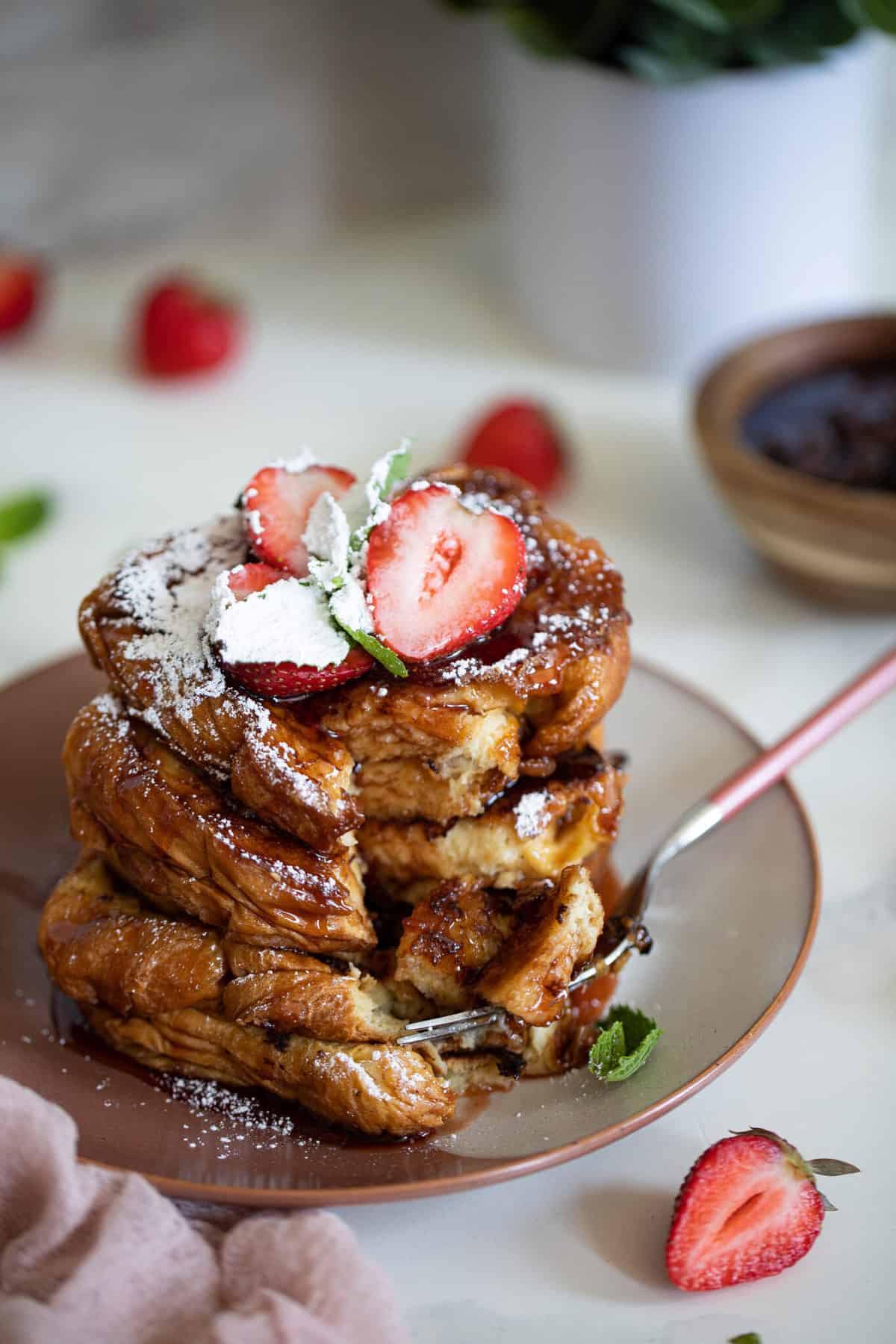 Stack of Balsamic Strawberry Brioche French Toast on a plate with a fork.