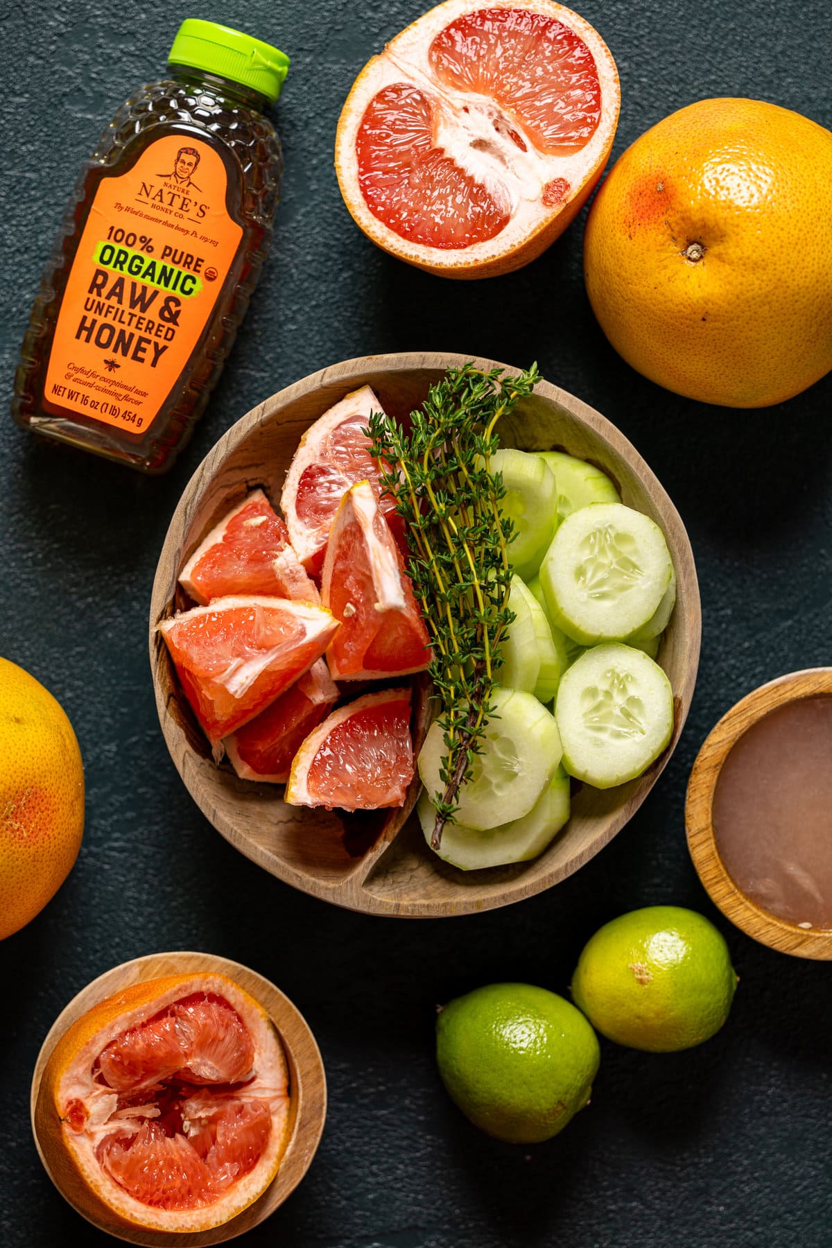 Ingredients for Honey Grapefruit Cucumber Thyme Tea including limes, grapefruits, and cucumbers