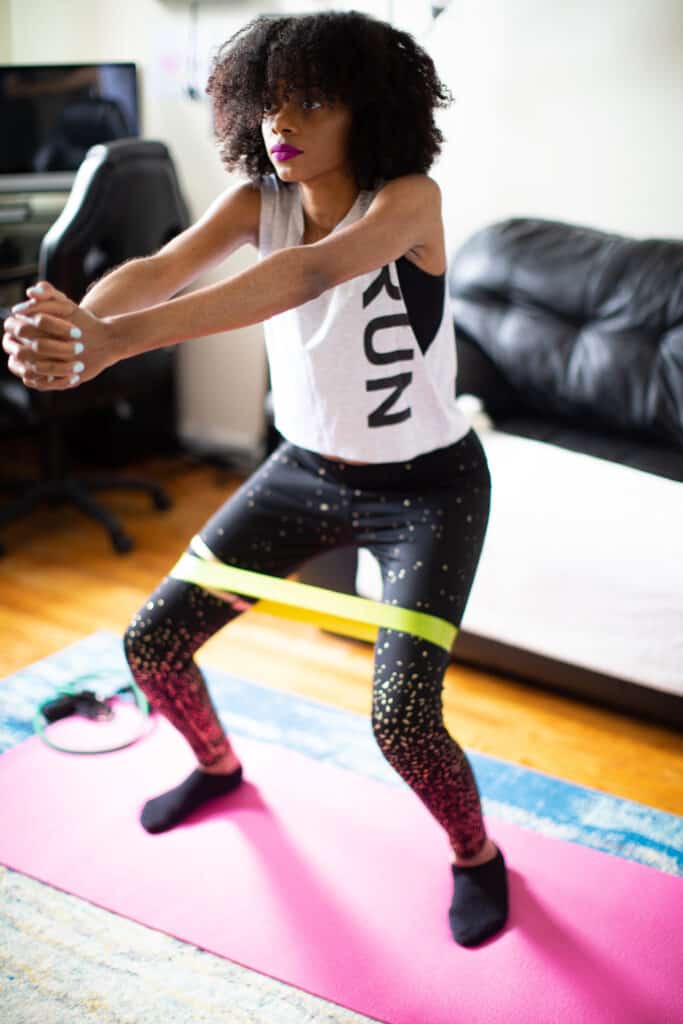 Shanika exercising with a yellow band around her legs.